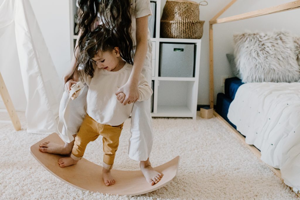 un bambino gioca con il supporto della mamma. Il metodo Montessori è basato sull'interazione tra il bambino, l'adulto e l'ambiente preparato