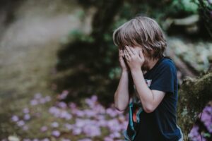 bambino che si copre la faccia