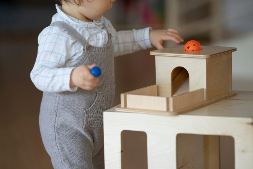 Un bambino che gioca con la scatola di permanenza, un attivita del metodo Montessori