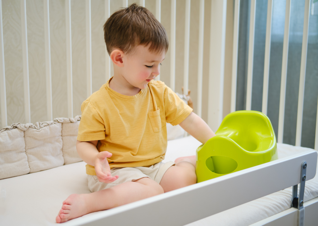 bambino seduto vicino al vasino. Per capire quando togliere il pannolino dobbiamo osservare i comportamenti dei bambini.