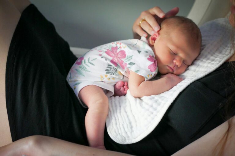 Bambino che dorme in braccio al genitore, simbolo di contatto, sicurezza e sonno sereno nei primi anni di vita