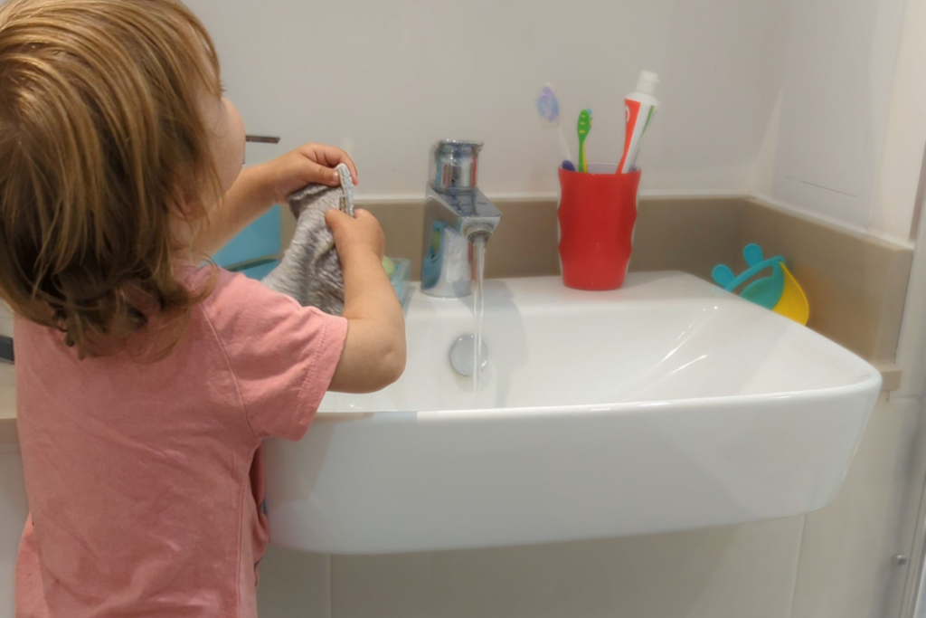 Bambina di spalle che si lava le mani