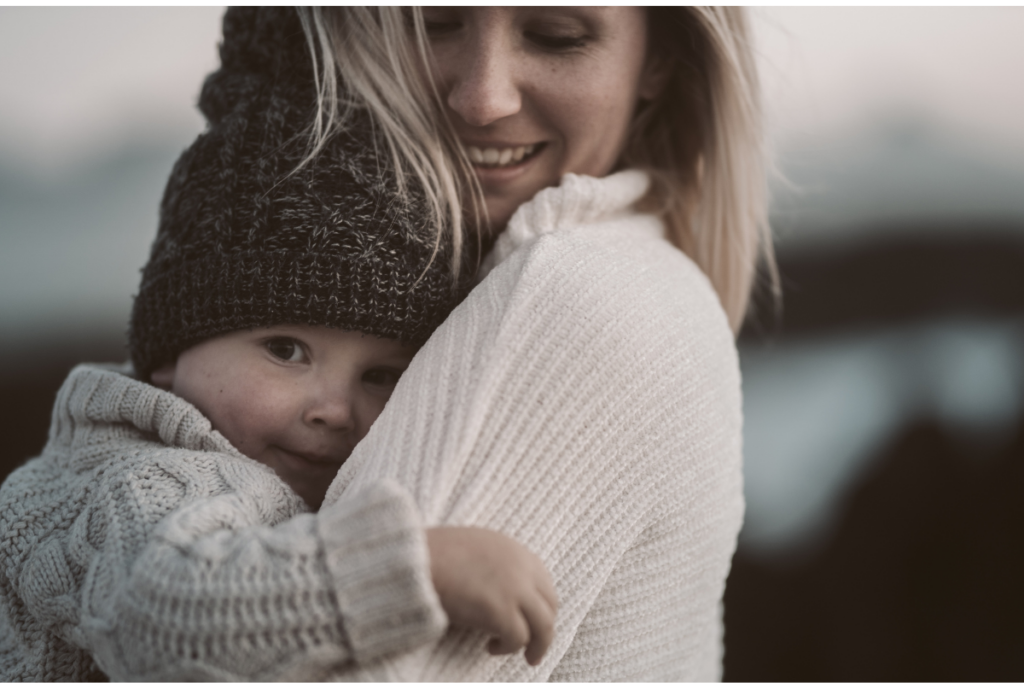 bambino piccolo in braccio alla mamma si nasconde