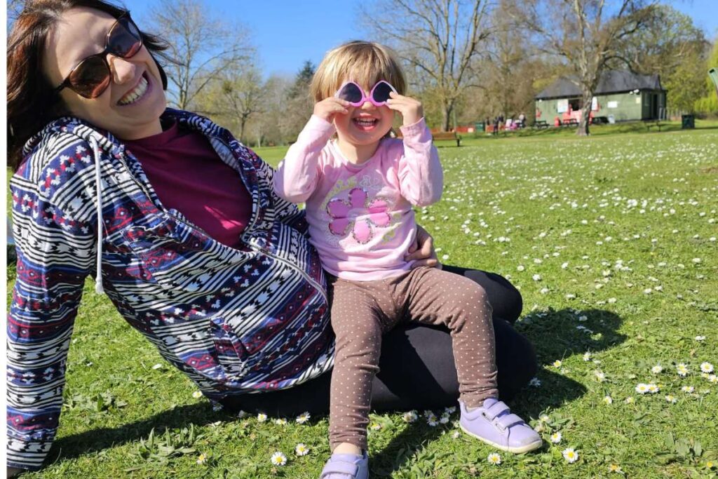 Mamma e figlia sedute a terra che sorridono