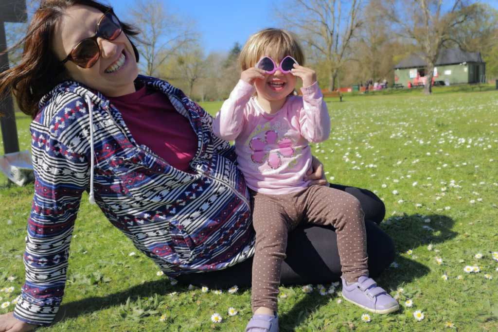 Mamma e figlia sedute a terra che sorridono - Come farsi ascoltare dai bambini