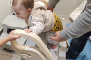 Bambino di 6 mesi si arrampica su uno sgabello