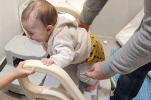 Bambino di 6 mesi si arrampica su uno sgabello
