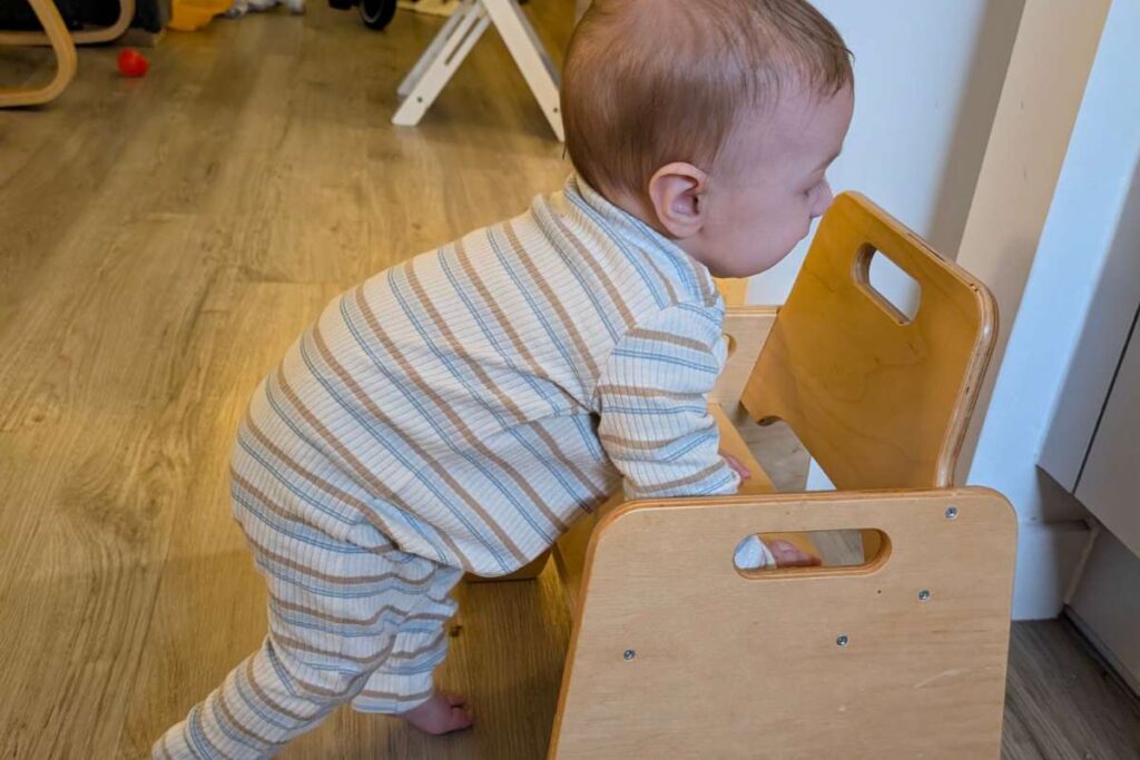 Bambino che si arrampica su una seggiolina piccola, a misura di bambino