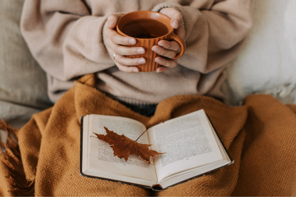 donna con in mano una tazza di caffe e un libro