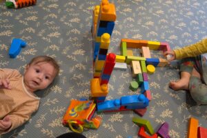 bambino neonato e sorellina che giocano insieme - cose-che-semplificano-la-vita-con-due-figli