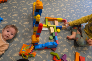 bambino neonato e sorellina che giocano insieme - cose-che-semplificano-la-vita-con-due-figli