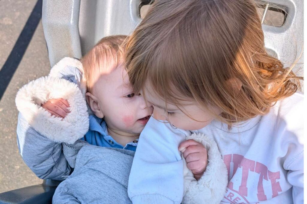 Due fratellini seduti uno vicino all'altra