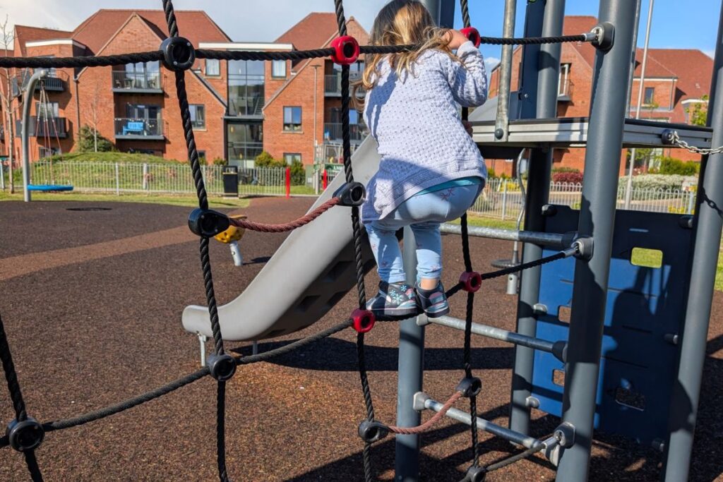 Bambina si arrampica al parco