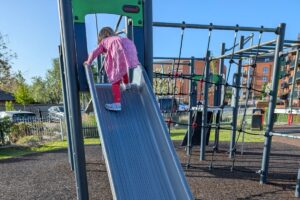 Bambina che si arrampica su uno scivolo